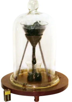 Sablier sous cloche en verre sur socle bois, sable s'écoulant d'une ampoule à l'autre.