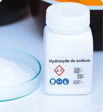 Flacon d'hydroxyde de sodium avec pictogrammes de danger, à côté de cristaux blancs.