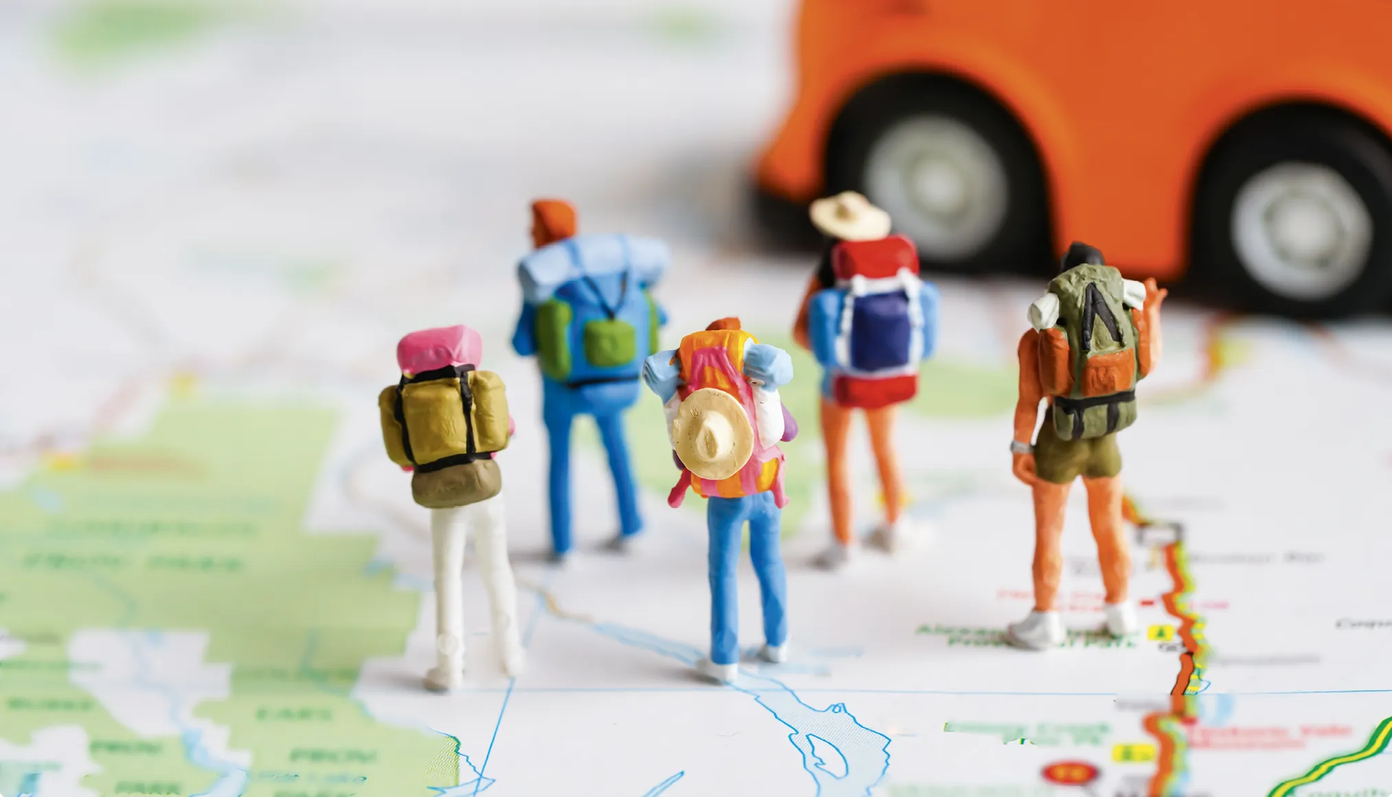 Small toy people on a map, ready to travel
