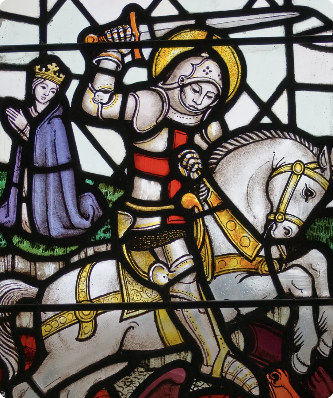 A victorian stained glass window depicting Saint George slaying a dragon.
