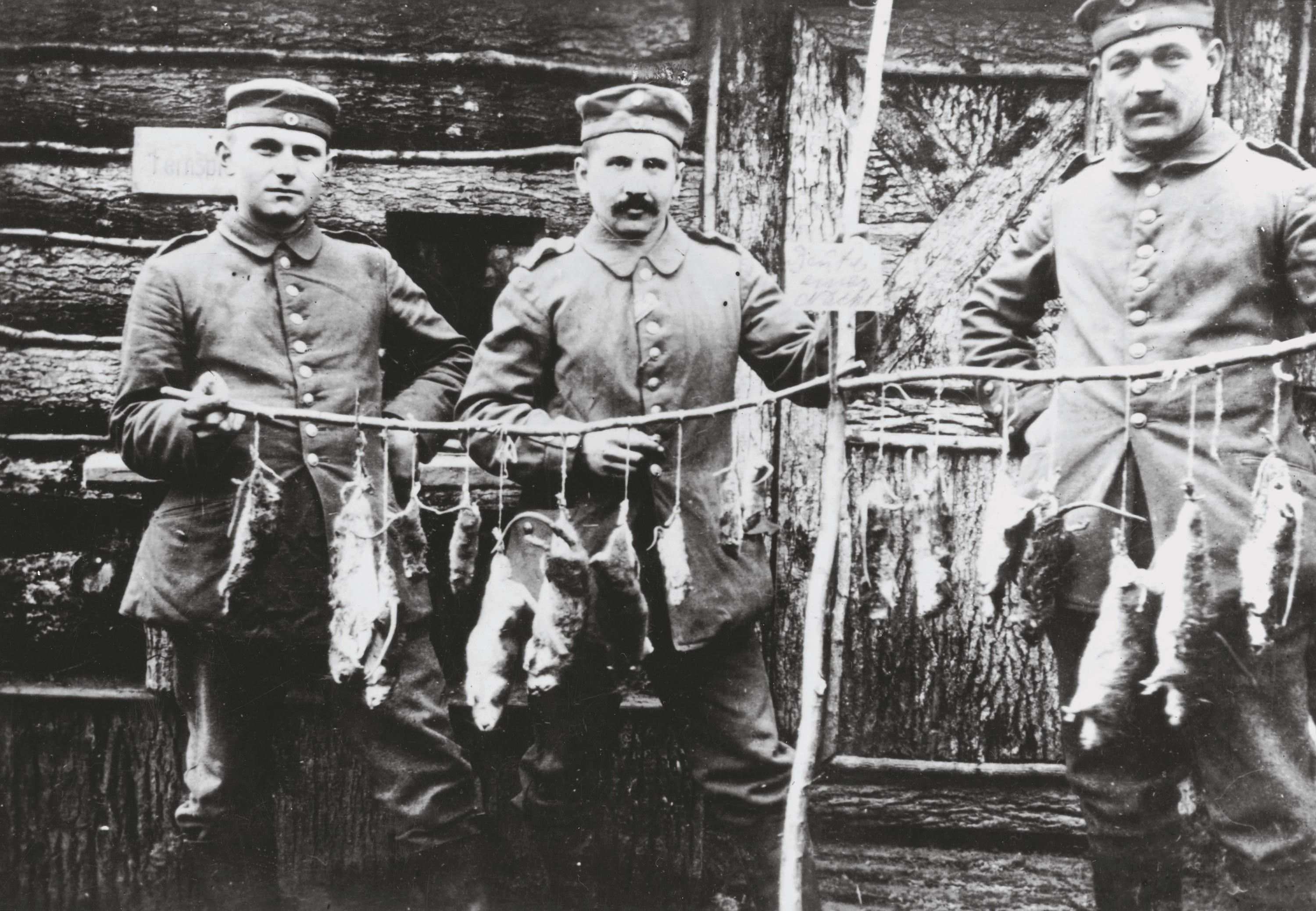 Des soldats (allemands) montrent les rats qu’ils ont pris.