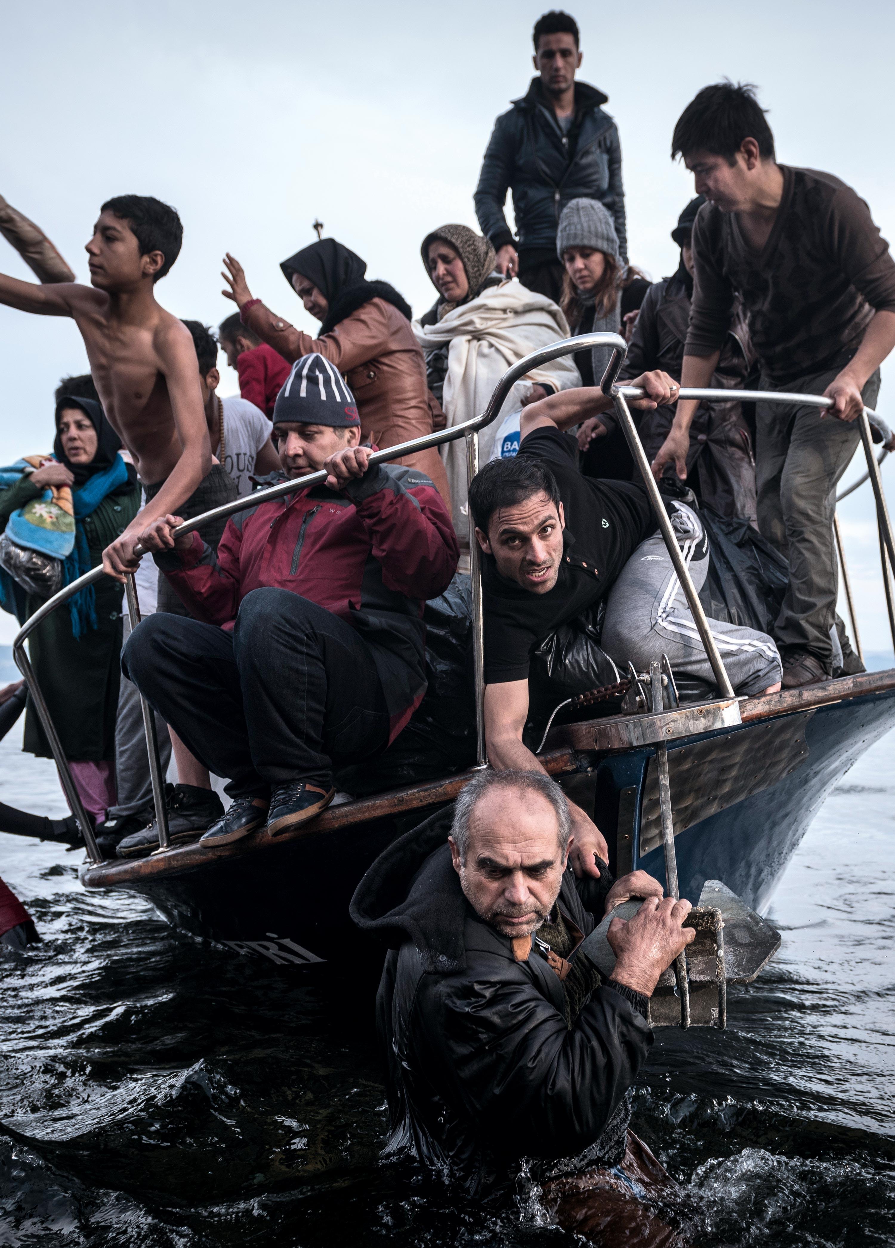 Migrants arrive by a Turkish boat near the village of Skala