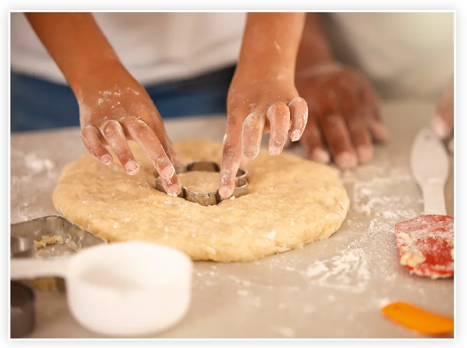 Mains préparant une pâte à biscuits avec un emporte-pièce
