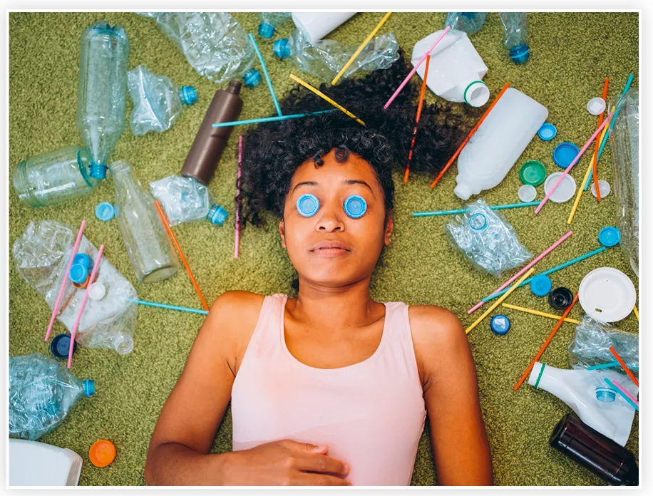 Une jeune fille allongée entourée de déchets plastiques