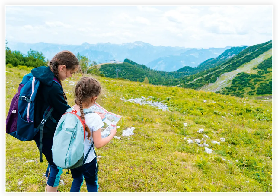 Deux enfants regardant une carte lors d'une course d'orientation en montagne