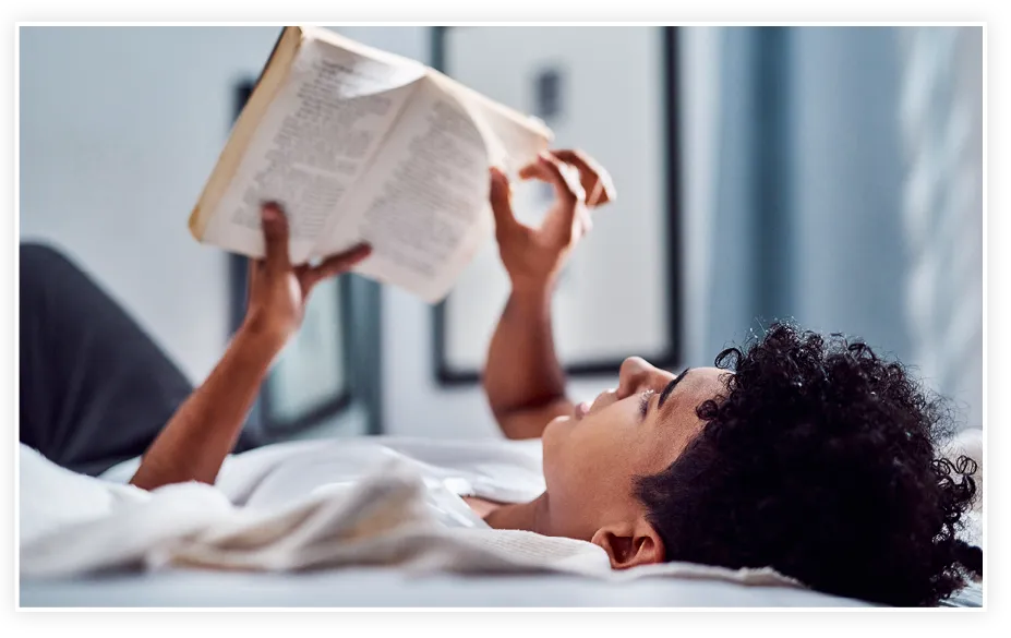 Personne allongée lisant un livre