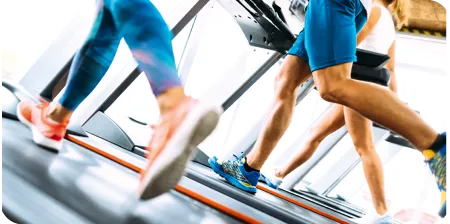 Des personnes s'entraînant sur des tapis de course dans une salle de sport