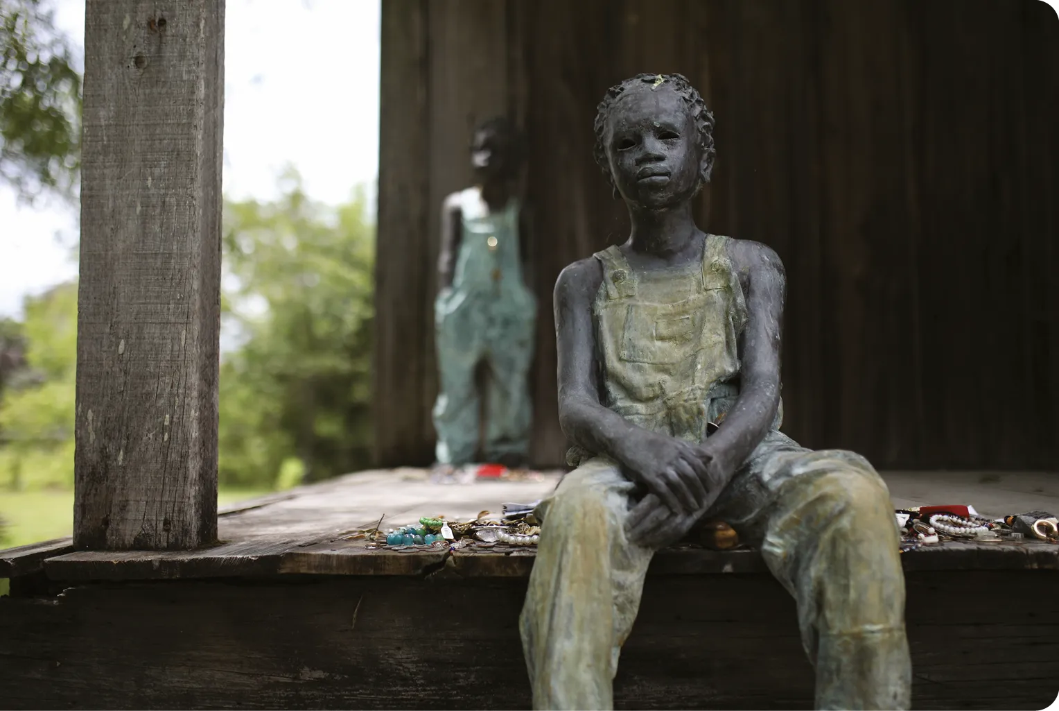 A sculpture by artist Woodrow Nash depicts two enslaved children, on the porch of a former slave cabin at the Whitney Plantation, 2025.