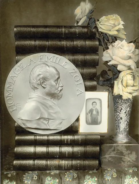 Photographie d'un hommage à Émile Zola : médaille, livres, roses et portrait d'enfant.