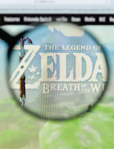 Photographie : gros plan de la jaquette du jeu vidéo The Legend of Zelda : Breath of the Wild affichée sur un écran d'ordinateur.