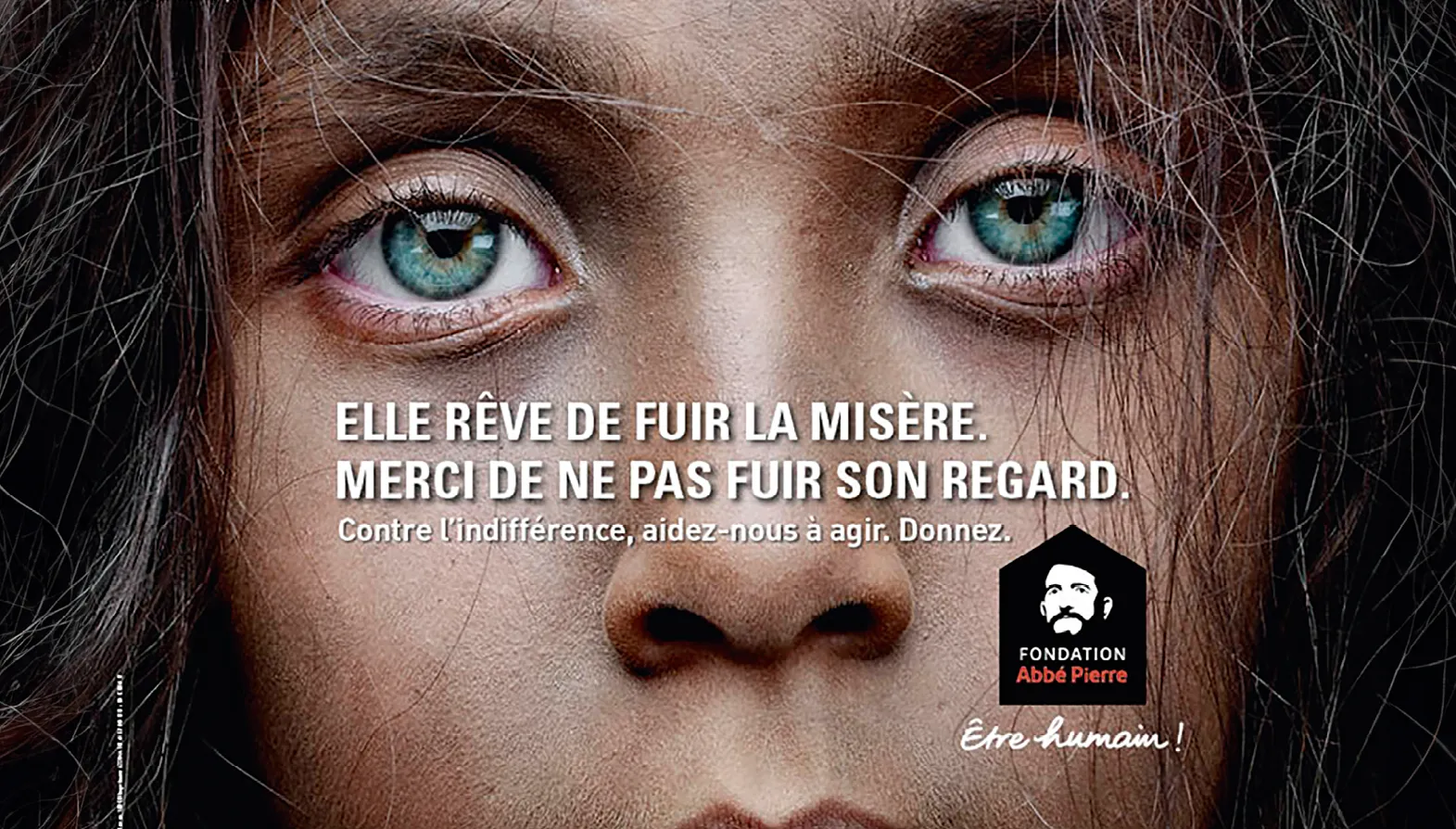 Photographie gros plan yeux enfant, appel don Fondation Abbé Pierre contre l'exclusion.