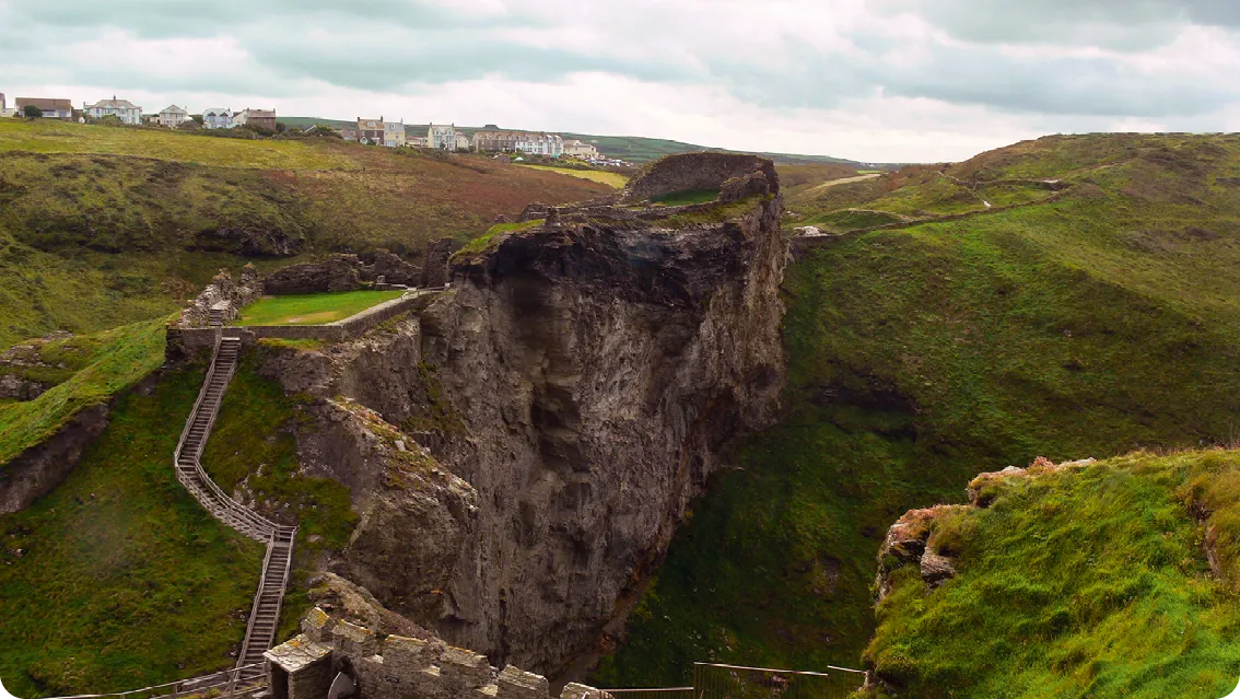 Photographie des ruines du château de Tintagel, Cornouailles. Escaliers menant aux vestiges médiévaux sur une falaise. Vue panoramique.