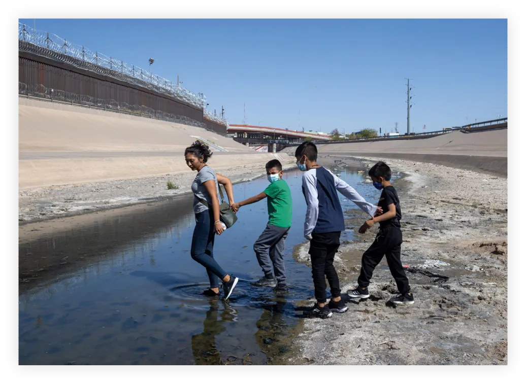 Una mujer y sus tres hijos en la frontera entre
México y Estados Unidos en Juárez, 2021.