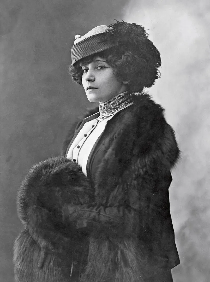 Photographie monochrome de Colette, jeune femme élégante en fourrure et chapeau à plumes.