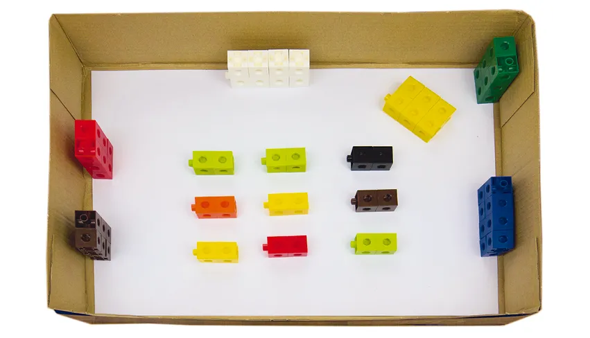 Photographie de blocs de construction multicolores rangés dans une boîte en carton. Jeu éducatif pour enfants.