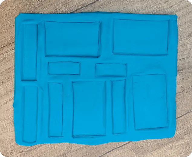 Pâte à modeler bleue avec empreintes géométriques. Activité manuelle créative enfant.