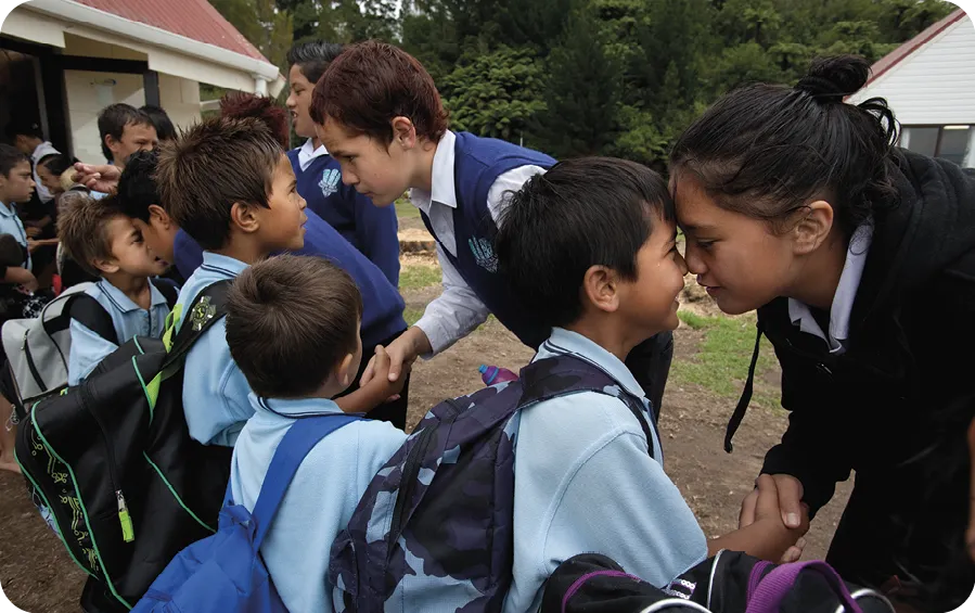 Students say goodbye to each other with a hongi, a traditional Maori greeting, at their school.