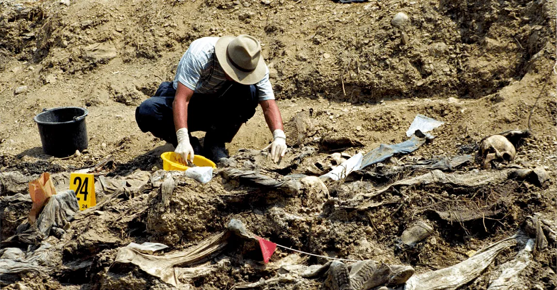 Expert identifiant des victimes dans un charnier de Srebrenica, 21 mars 2013, photographie.