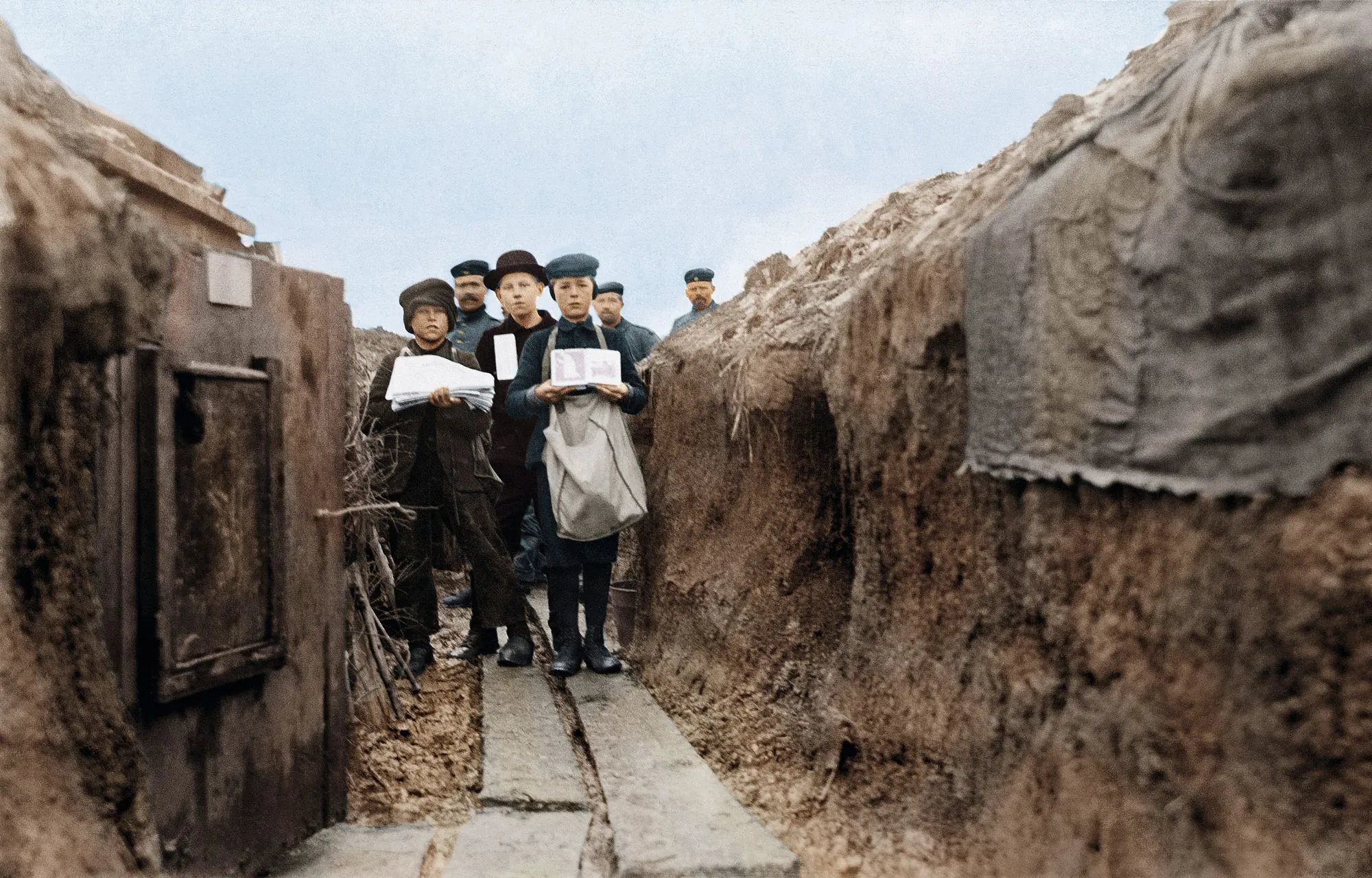 Enfants vendant des journaux aux soldats dans une tranchée allemande sur le front de l'Est