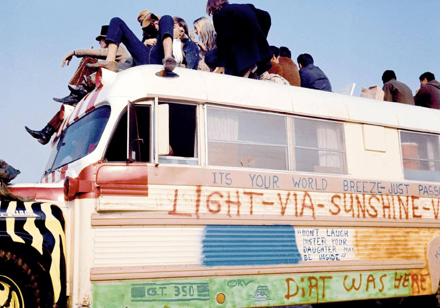 A group of hippies sit on top of a graffi ti-painted bus during Altamont free rock concert, 1969.