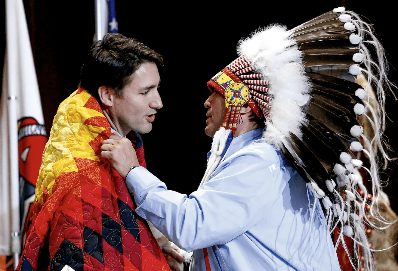 National Chief Perry Bellegarde adjusts a blanket presented to Prime Minister Justin
Trudeau during the Assembly of First Nations Special Chiefs Assembly in Gatineau