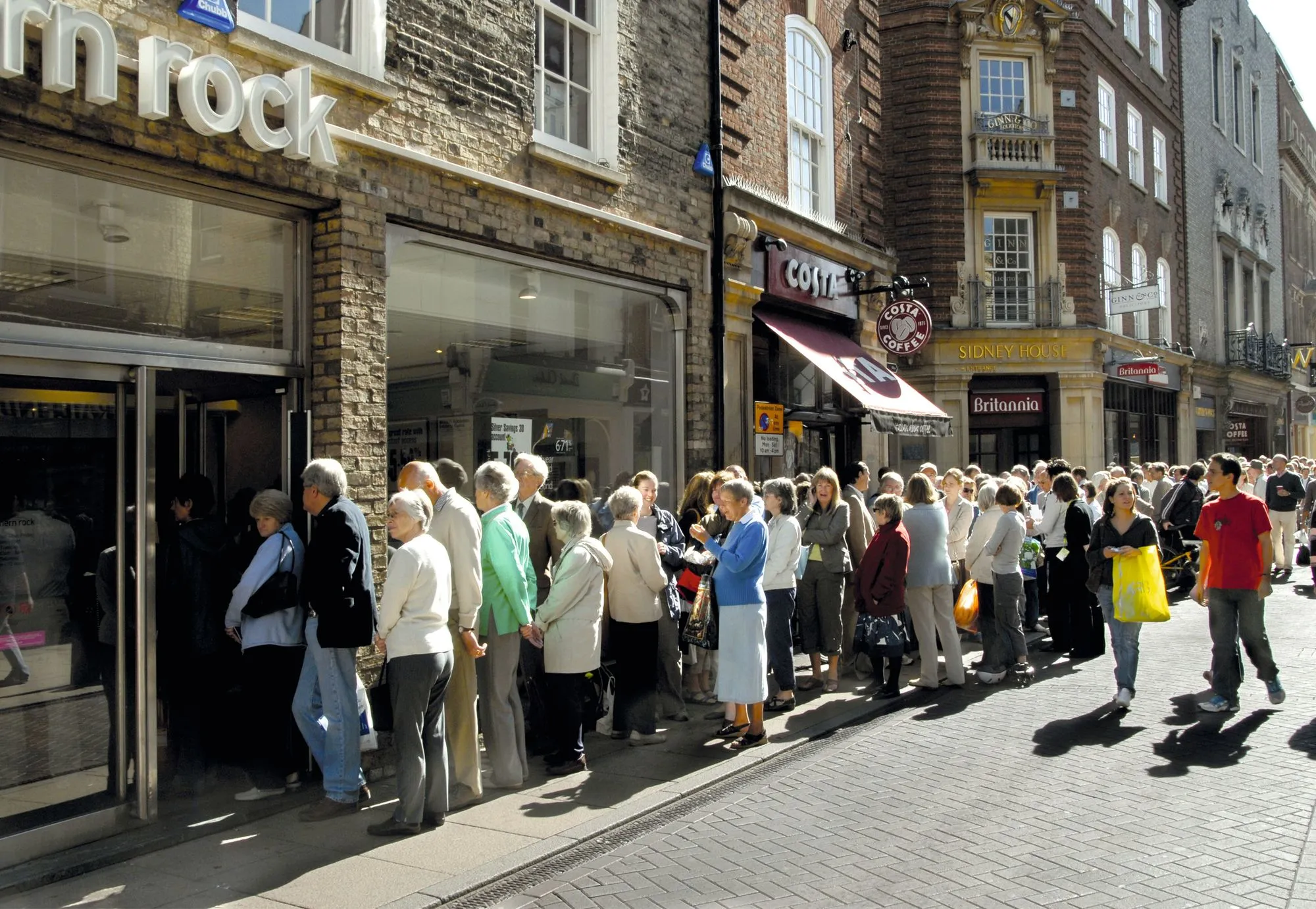 les clients de la Northern Rock, en Angleterre, font la queue pour retirer leur argent liquide