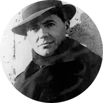 Photographie noir et blanc de Jean Moulin, résistant français, chapeau et écharpe.