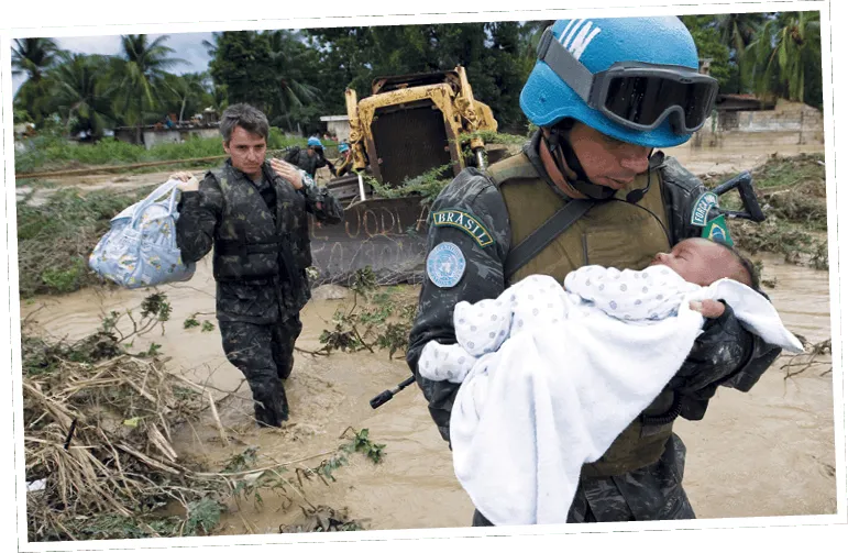 Un Casque bleu brésilien, à Haïti, met un bébé en sécurité après une tempête en octobre 2007.