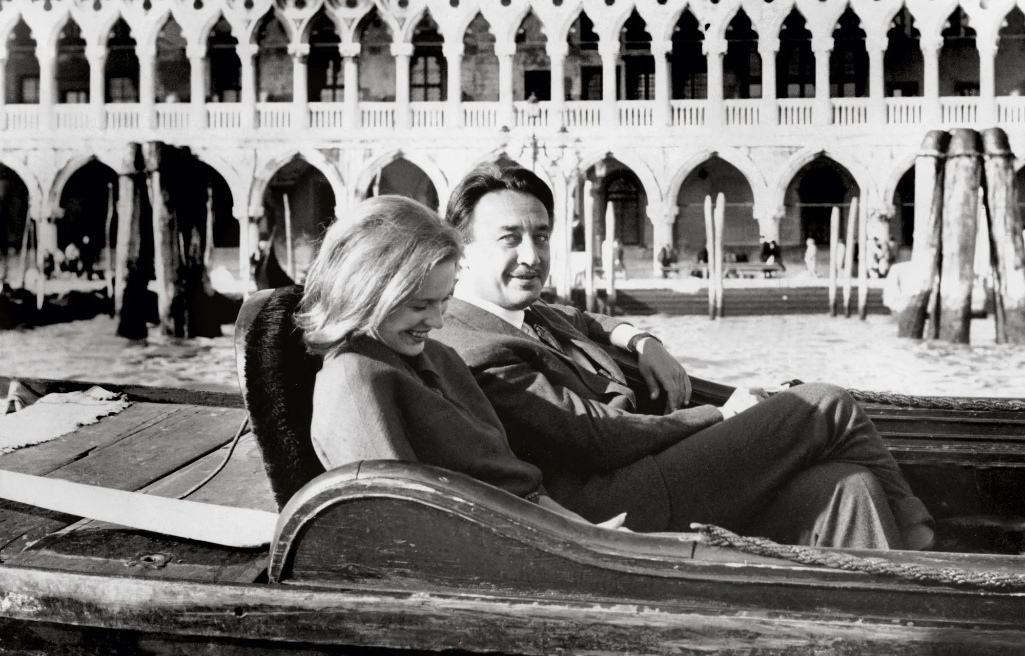 Photographie en noir et blanc de Romain Gary et Jean Seberg, souriants, assis dans une gondole à Venise.