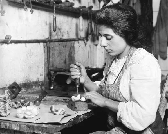 Femme en 1900 assemblant des fleurs artificielles