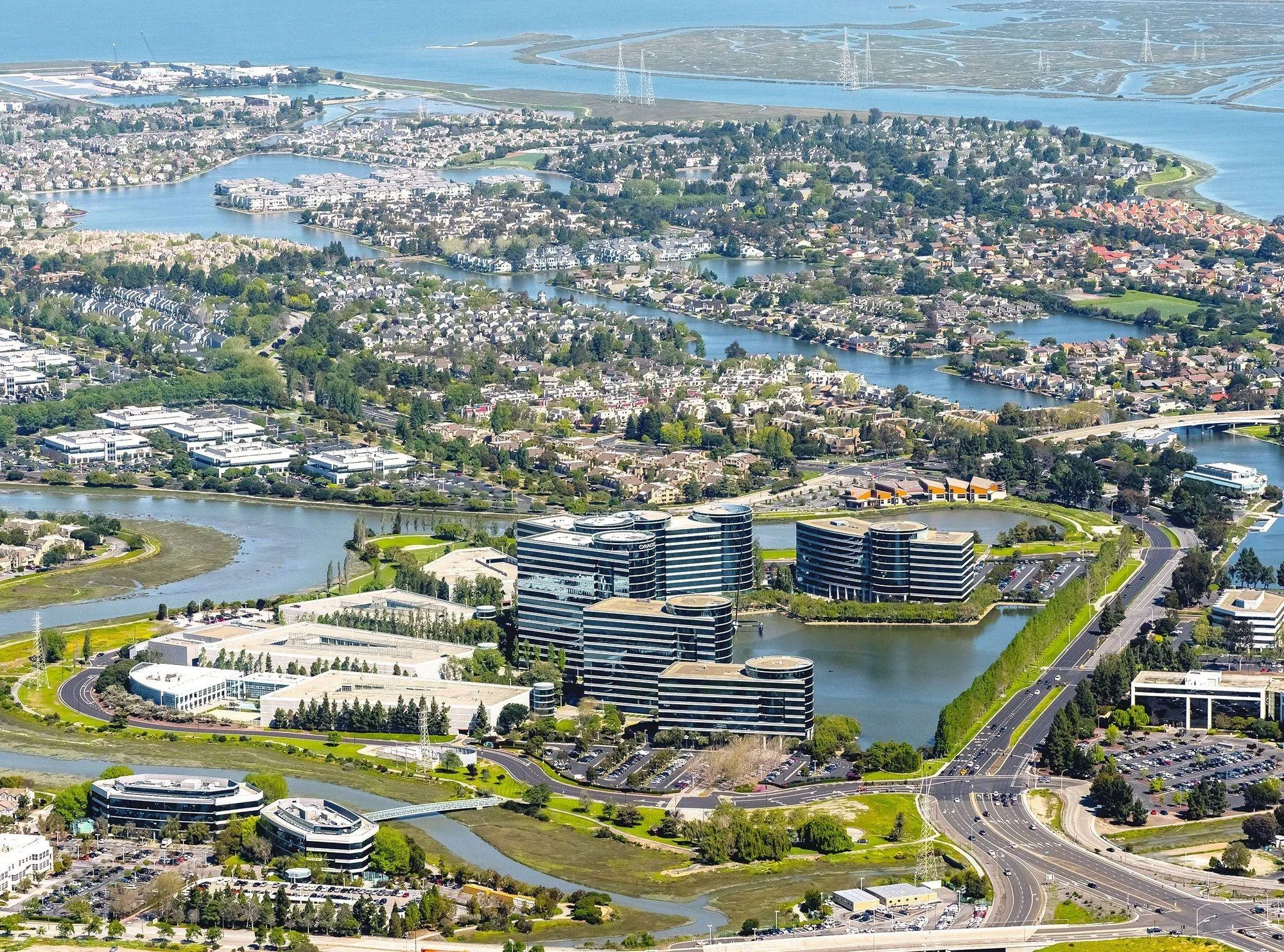 Photo aérienne de la Silicon Valley montrant des bâtiments de bureaux modernes, des zones résidentielles et des plans d'eau.