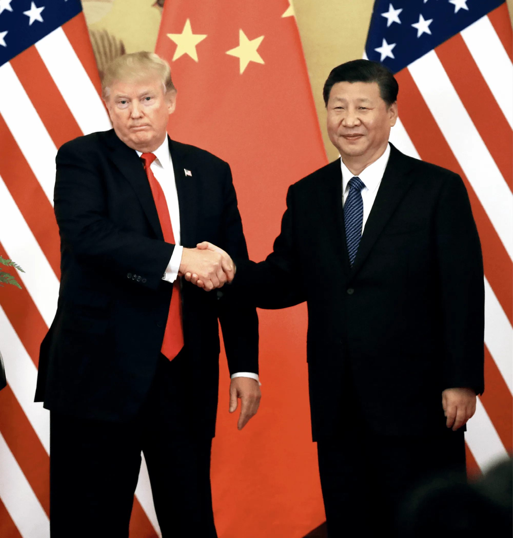 Photographie de Donald Trump et Xi Jinping se serrant la main, drapeaux américains et chinois en arrière-plan.