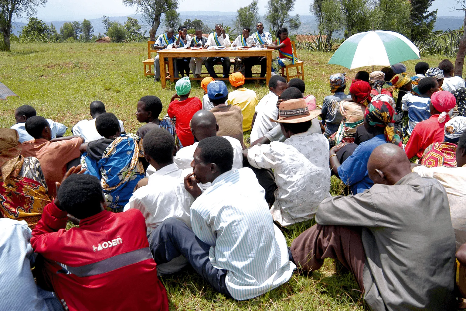 Photographie : audience attentive lors d'un procès gacaca à Zivu au Rwanda en 2003.  Des personnes assises écoutent des officiels à une table.