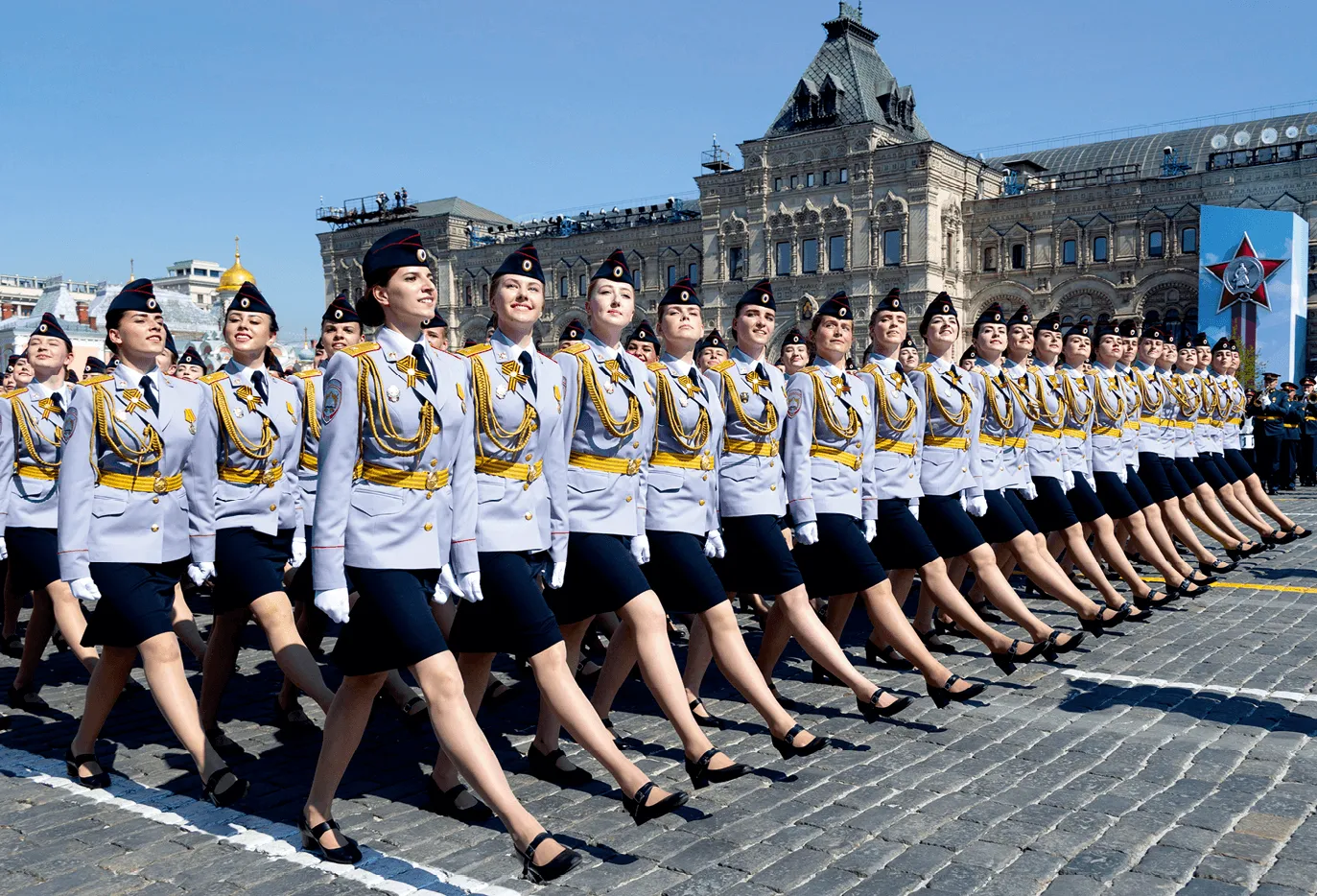 Photographie de femmes militaires défilant à Moscou lors d'une commémoration. Uniforme gris, décorations dorées.