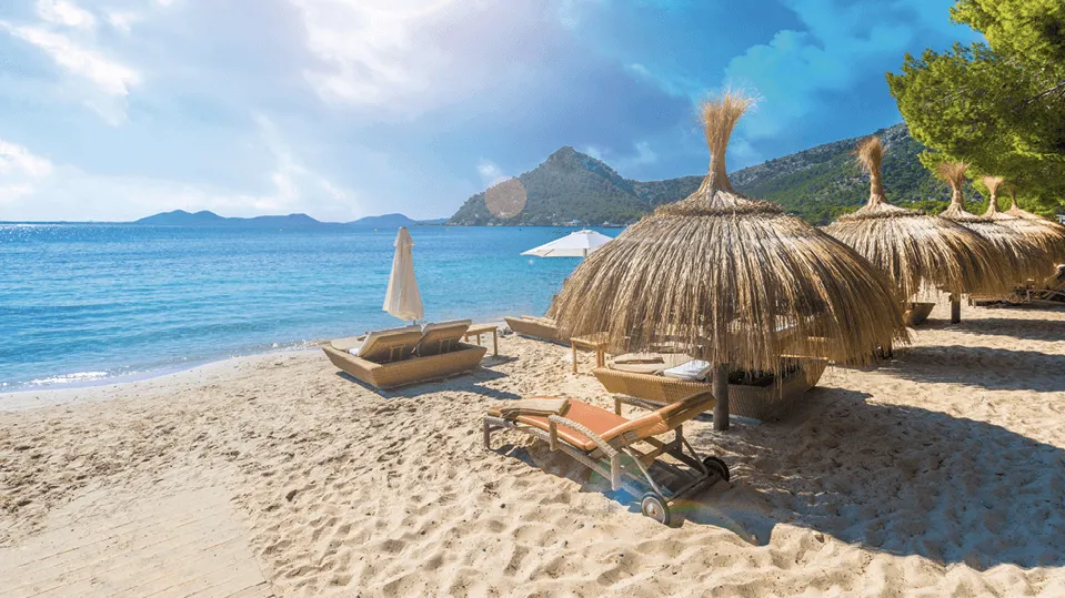 Photographie d'une plage paradisiaque avec parasols en paille, transats et eaux turquoise. Idéal pour vacances détente.