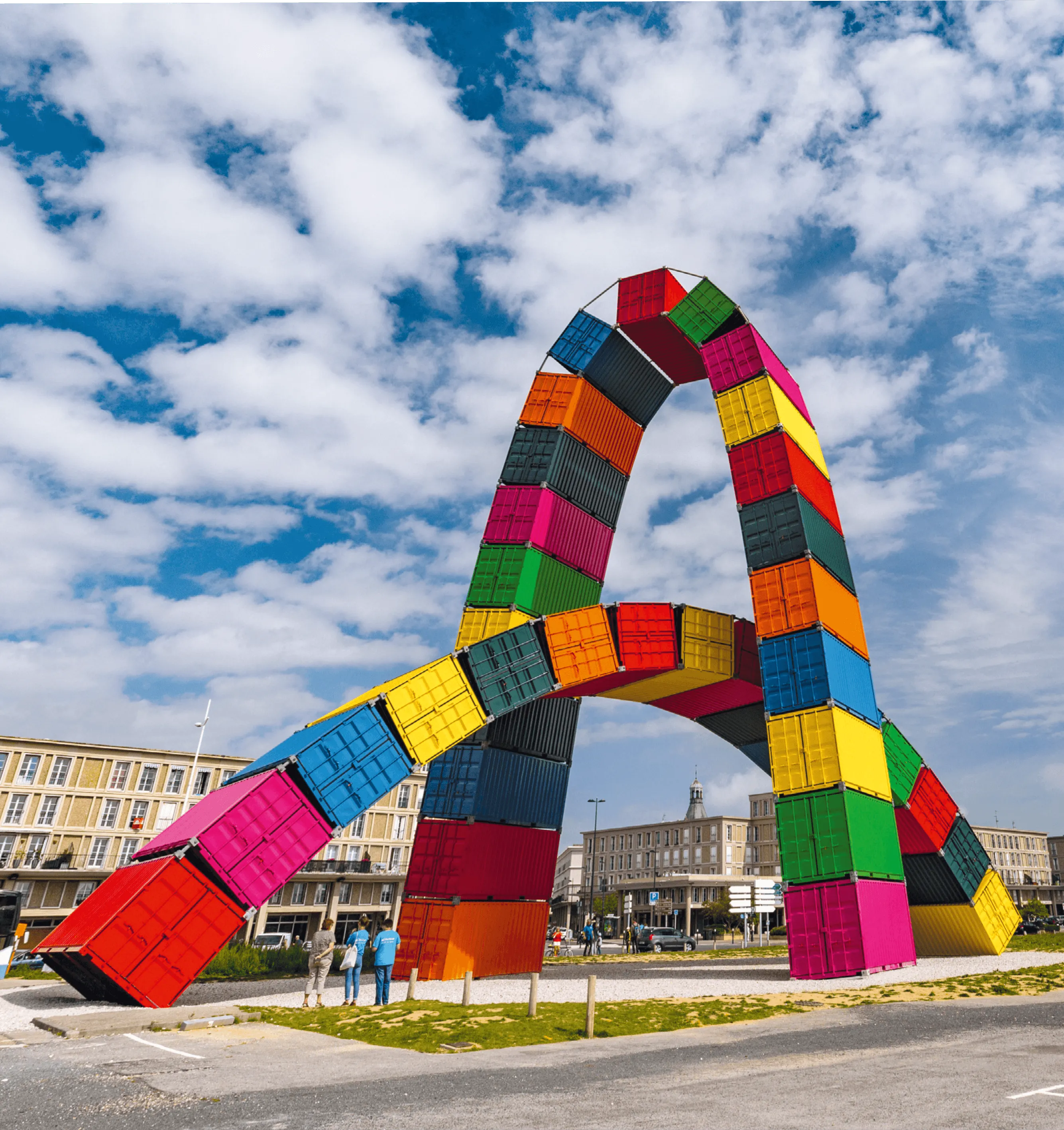 Photographie d'une sculpture colorée en forme d'arche, composée de containers empilés. Œuvre de Vincent Ganivet.