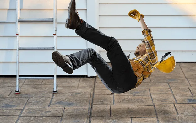 Photographie d'un ouvrier en chute près d'une échelle, accident du travail, sécurité.