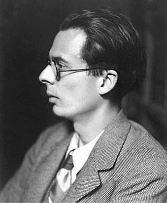 Photographie en noir et blanc d'Aldous Huxley, de profil, portant des lunettes et un costume.