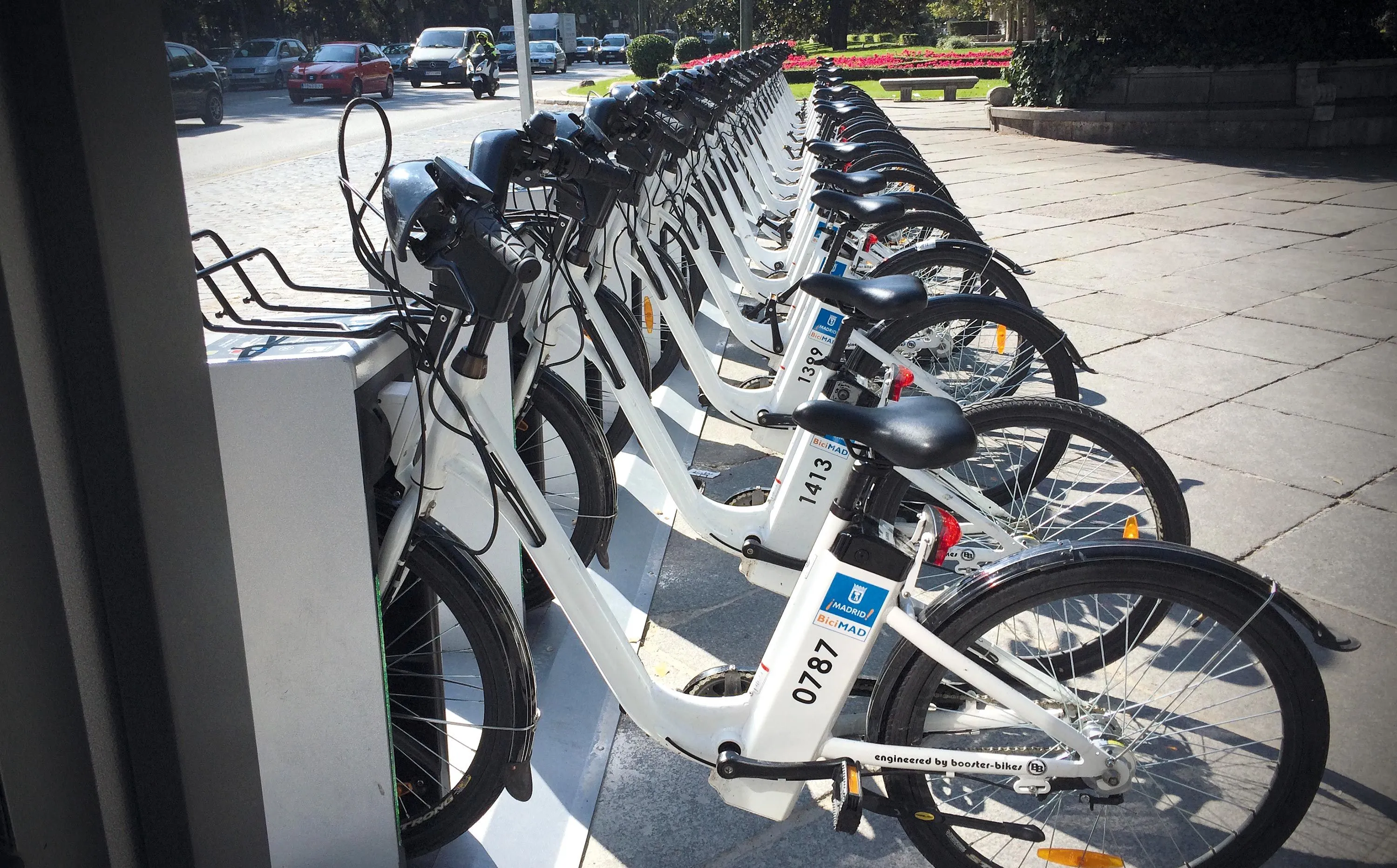 Photographie de vélos blancs en libre-service alignés, prêts à être utilisés. Vélos électriques du système BiciMAD à Madrid.