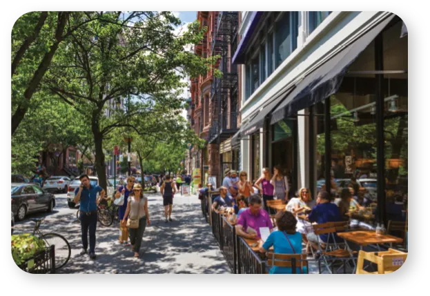 Street scene in Crown Heights with people sitting at outdoor tables.