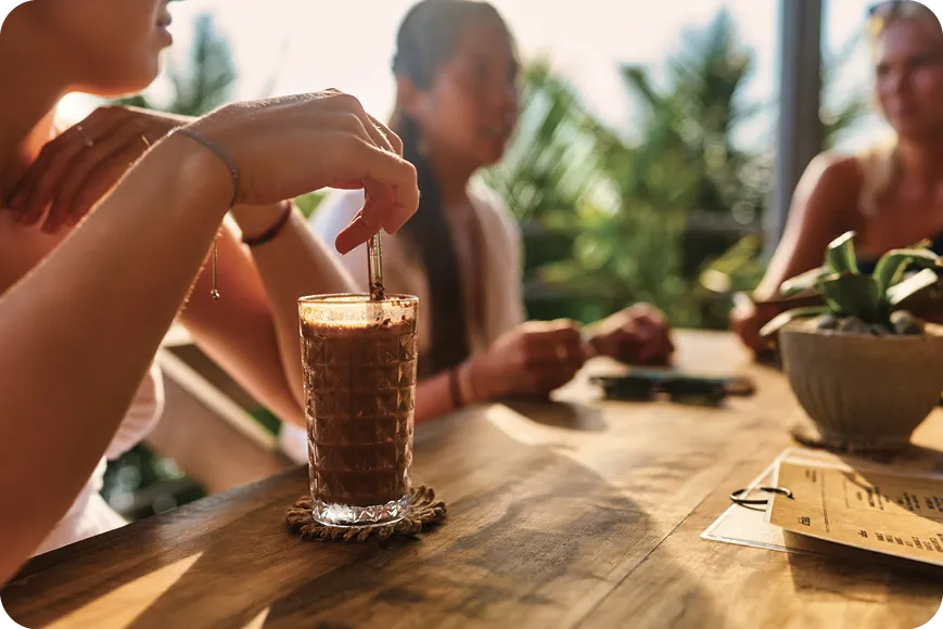 Un groupe d'amis se détendra dans un café en plein air avec des boissons glacées.
