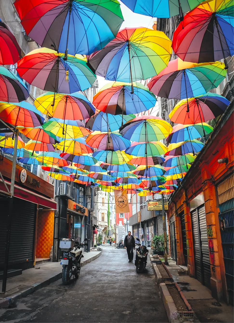 Autobahn, 24 avril 2017, photographie d'un homme marchant dans une rue décorée de parapluies dans le quartier de Karaköy, Istanbul, Turquie.